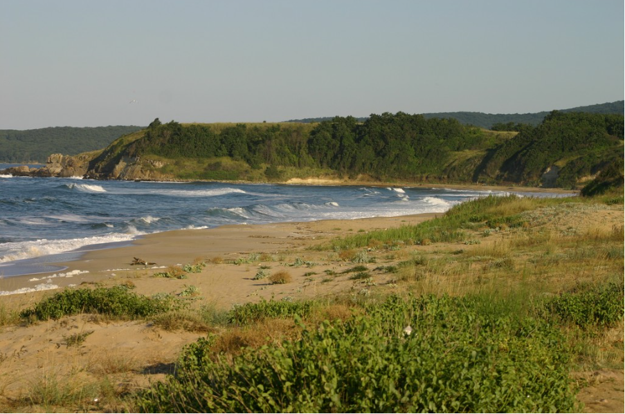 Море, скалист бряг, оскъдна ниска растителност и пясъчни дюни.